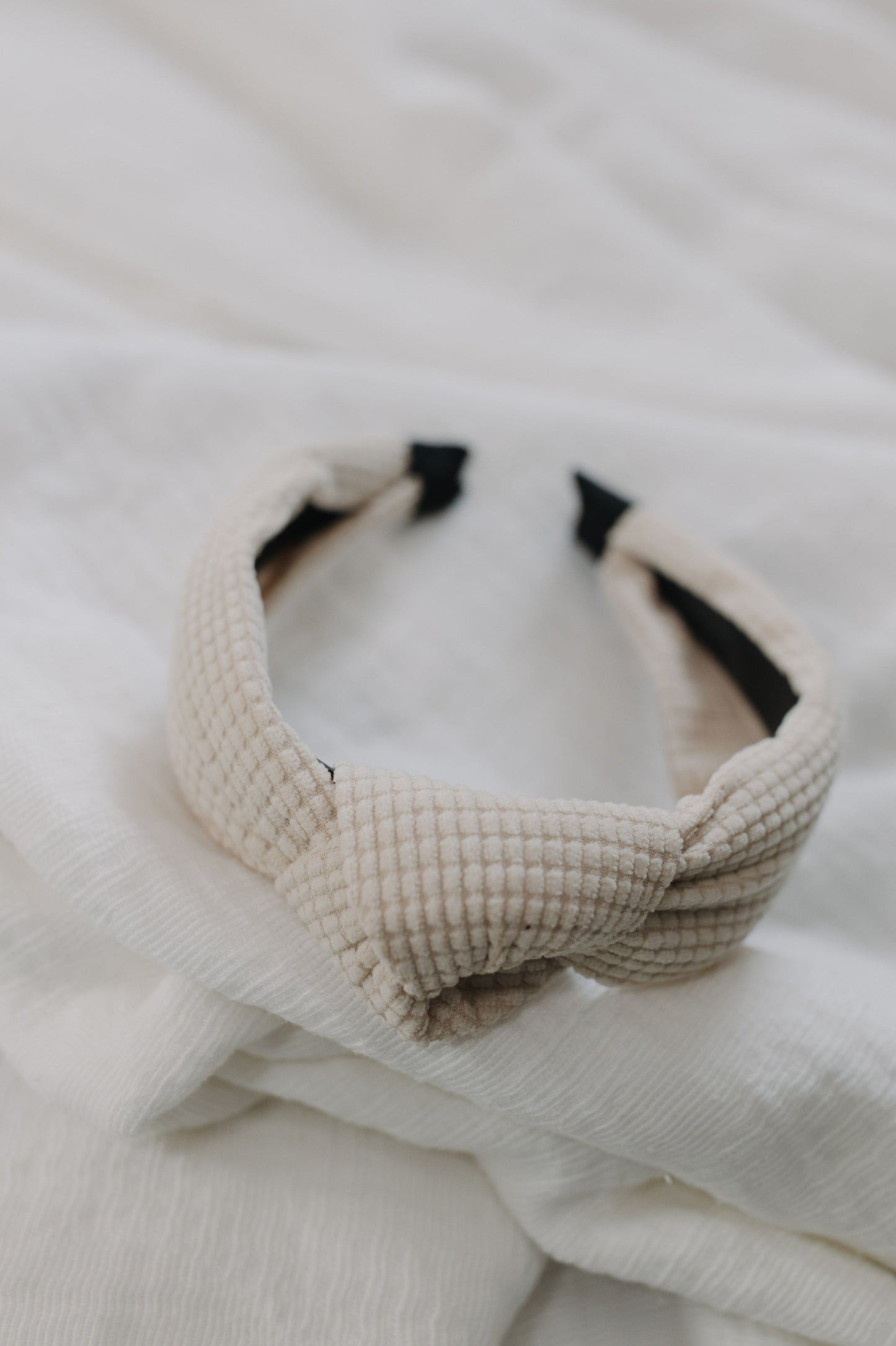 Cream waffle texture headband against a white background.