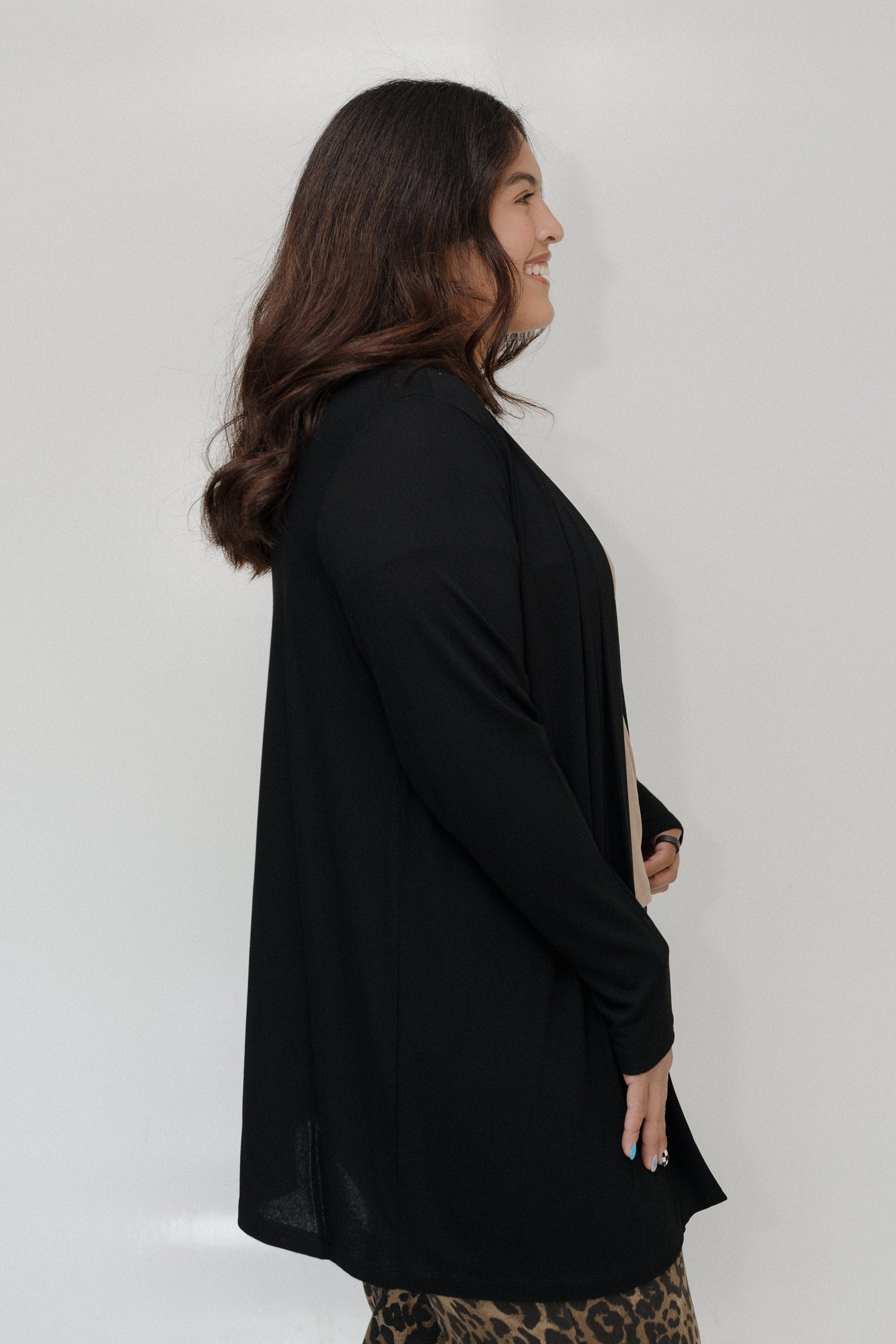 Woman wearing a black coat against a white background