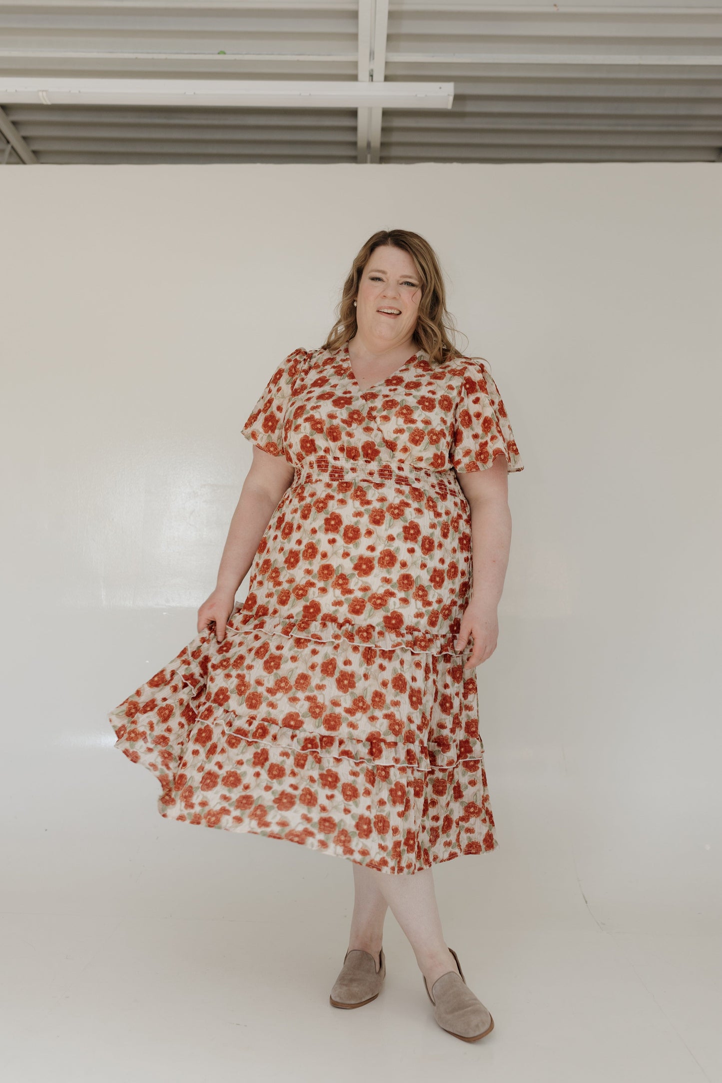 Woman wearing a floral dress against a plain background