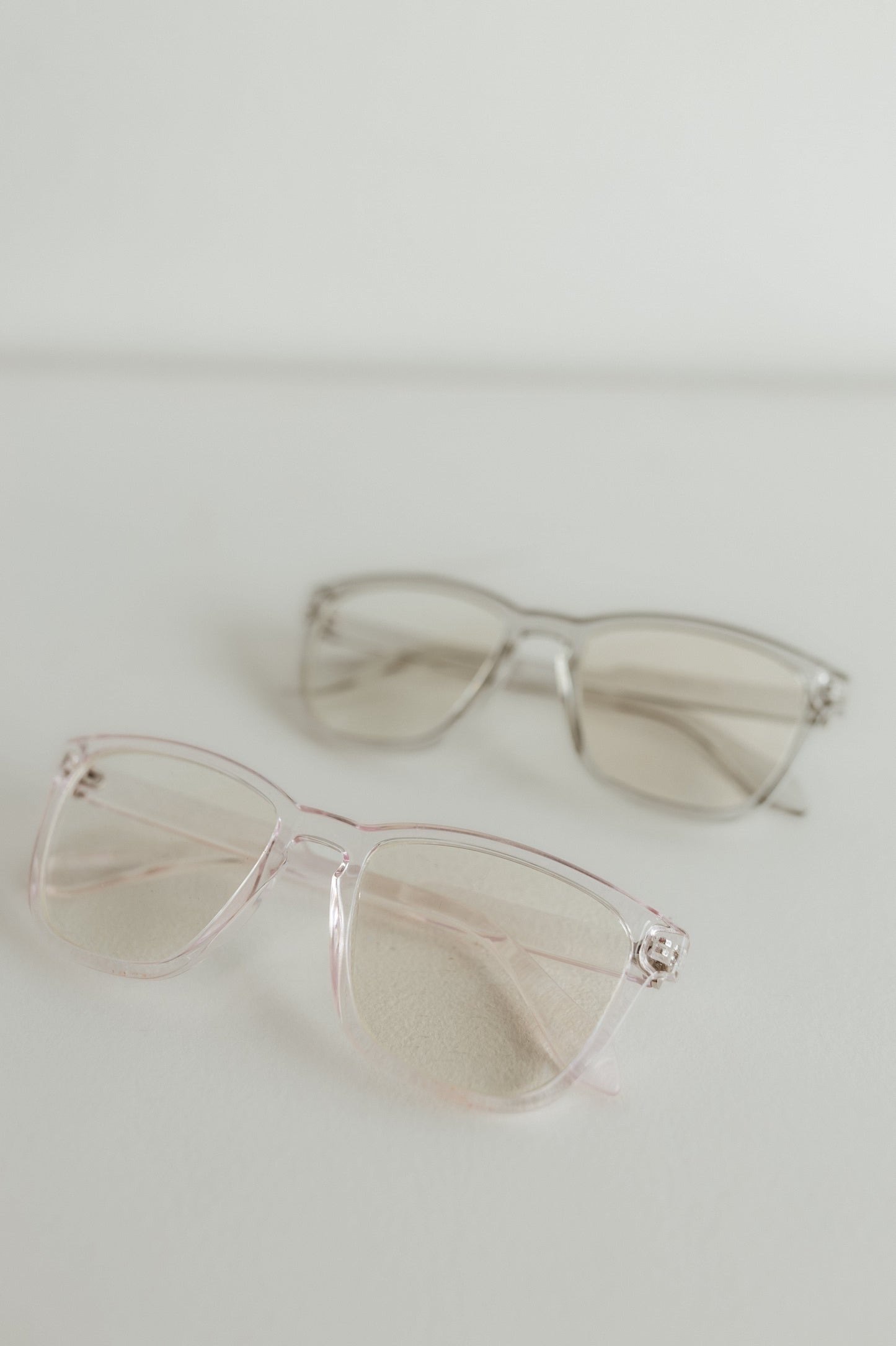 Clear sunglasses on a light gray background
