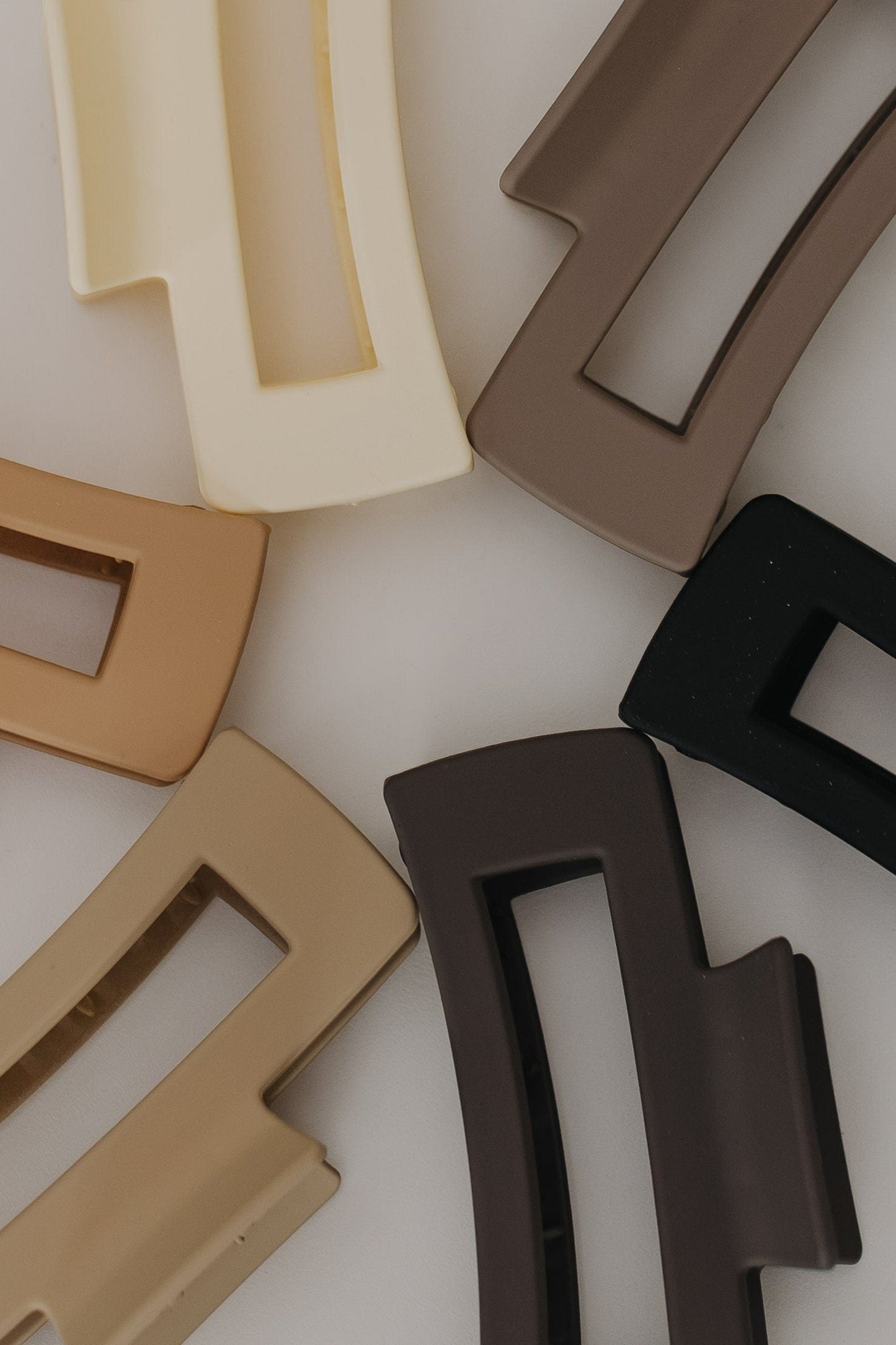 Set of rectangular plastic claw clips in various colors on a light background