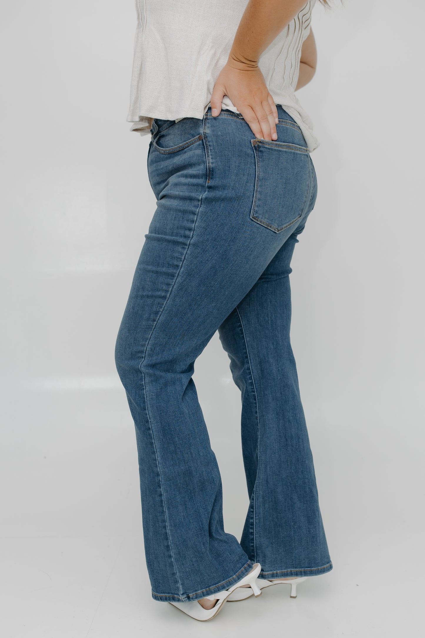 Person wearing blue jeans on a plain background