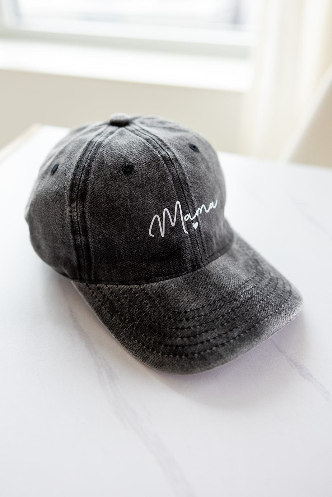 A faded black baseball cap, perfect for Mother's Day gifting, features