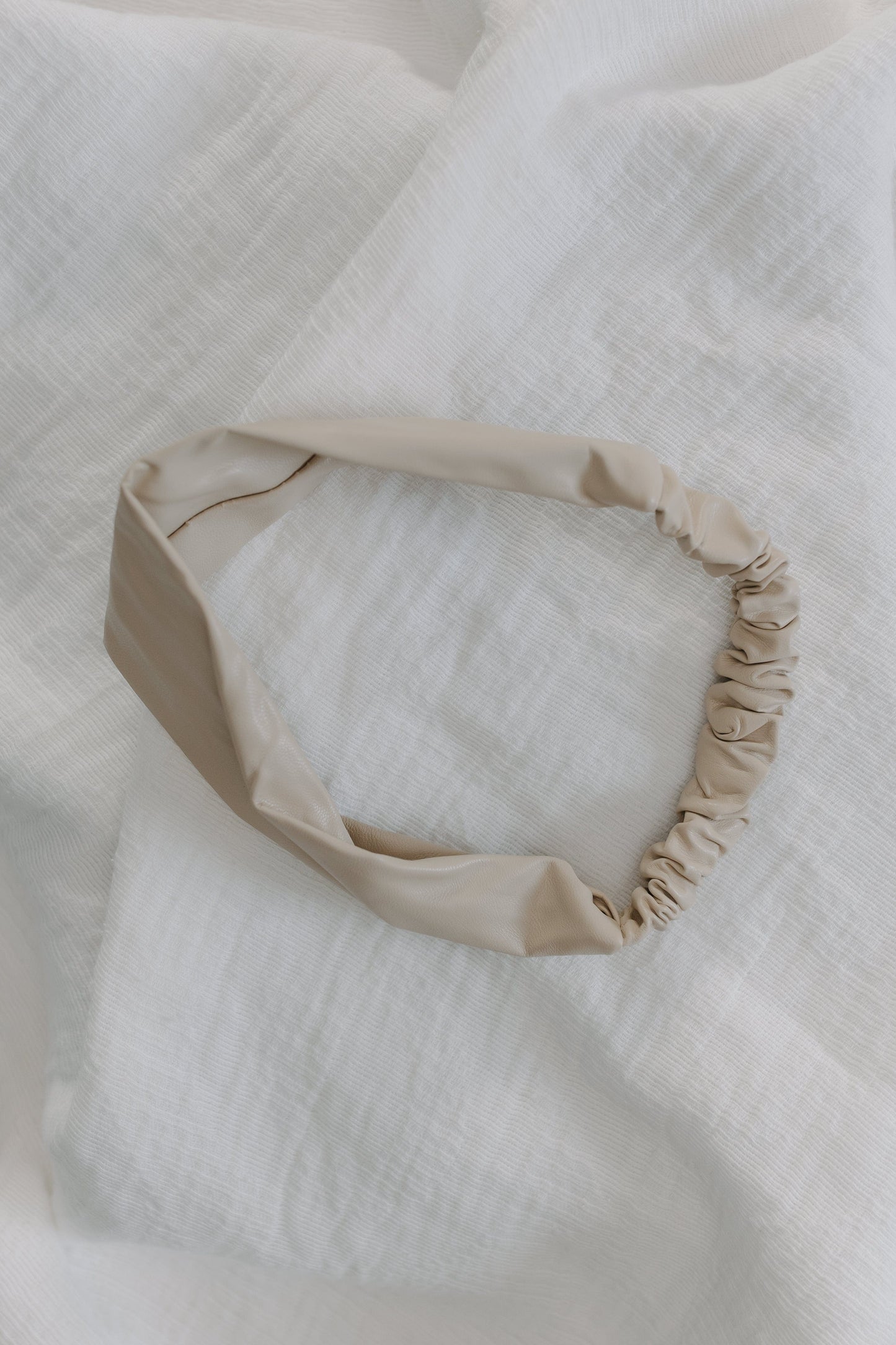 Sand headband on a textured white fabric background
