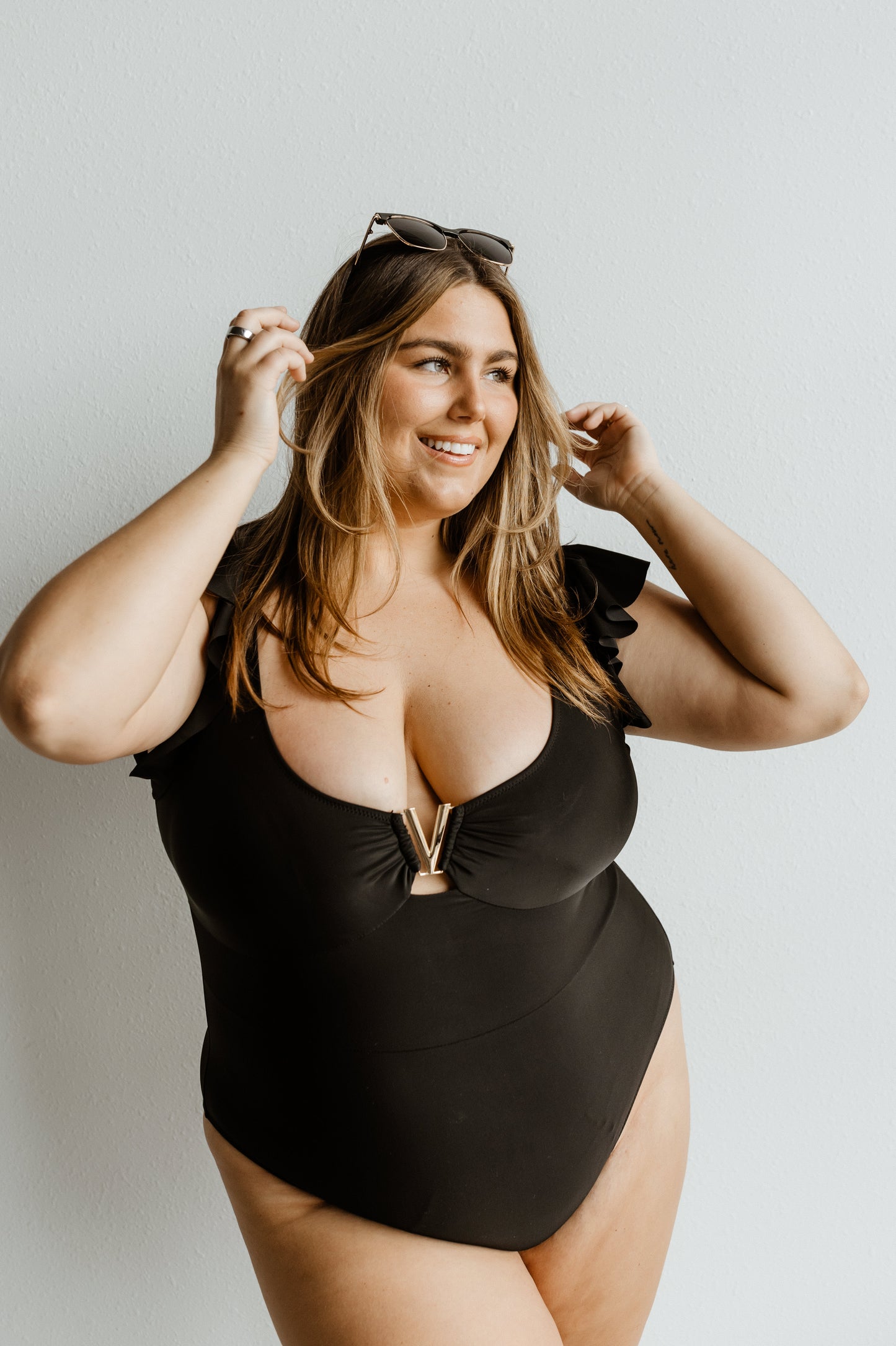 Woman wearing a black swimsuit against a plain background