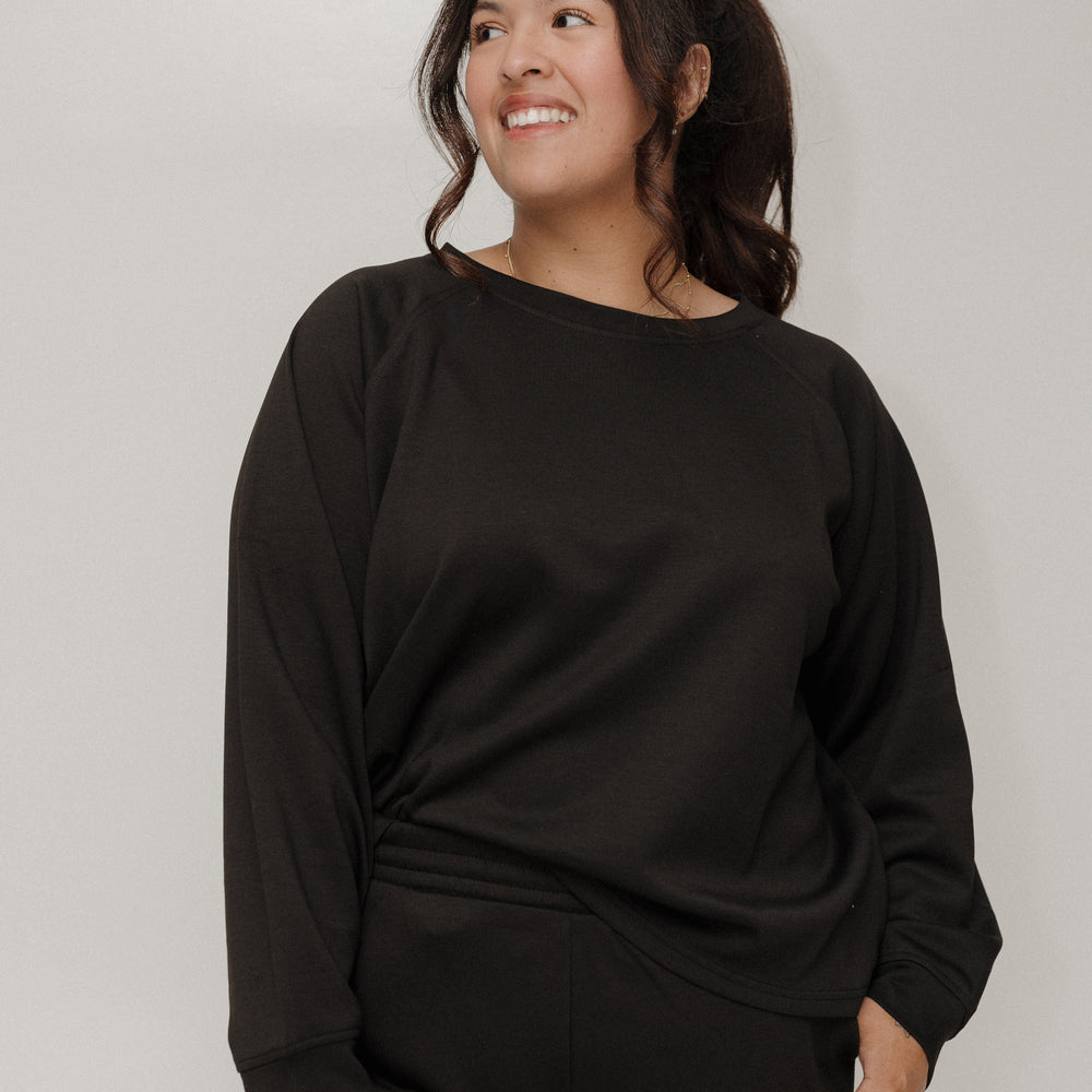 Woman wearing a black outfit against a plain background