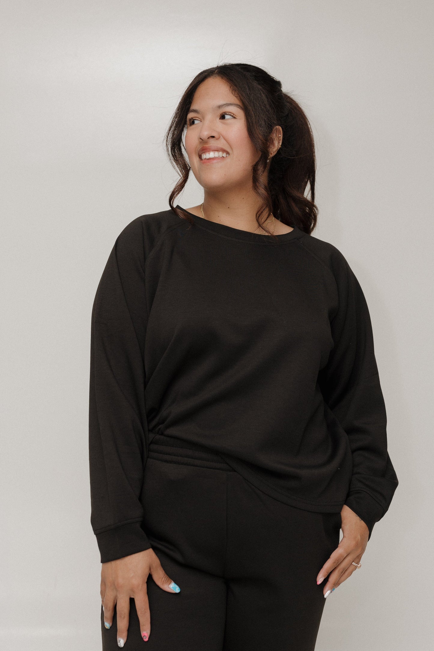 Woman wearing a black outfit against a plain background