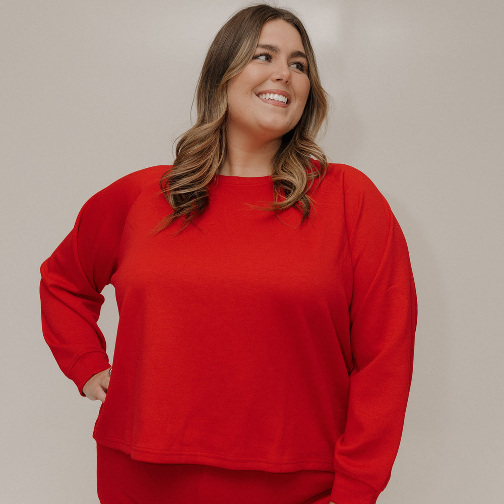 Woman wearing a red outfit against a plain background