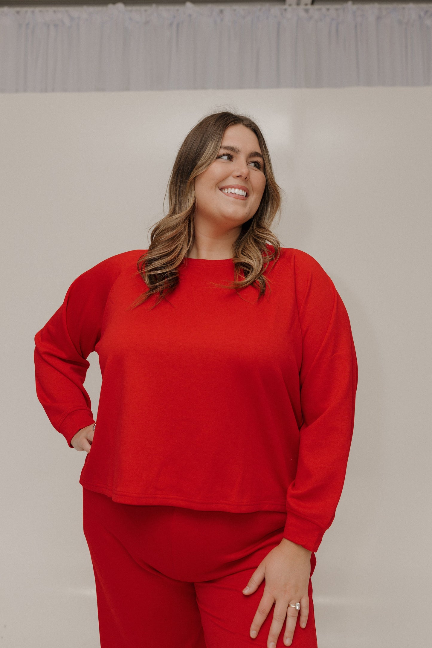 Woman wearing a red outfit against a plain background