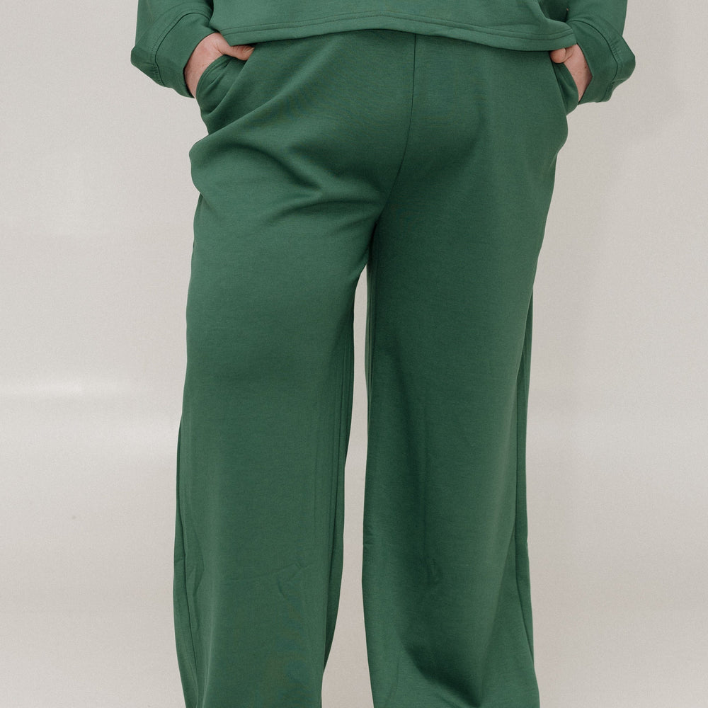 Green sweatshirt and pants set on a white background