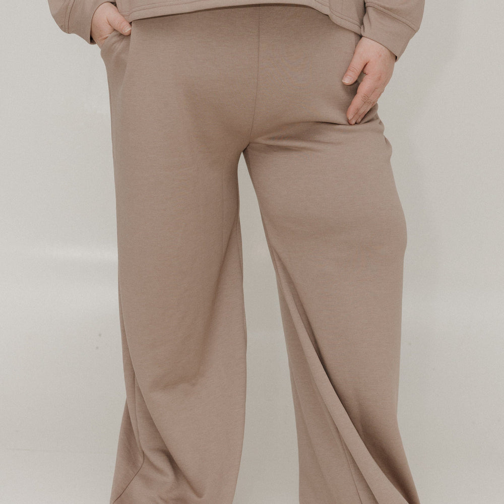 Beige sweatshirt and pants set on a white background