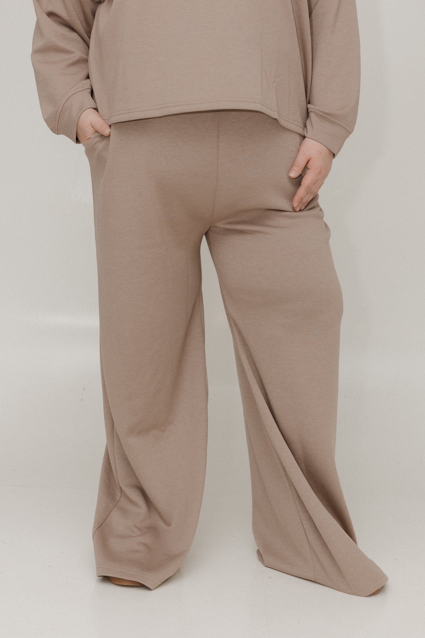 Beige sweatshirt and pants set on a white background