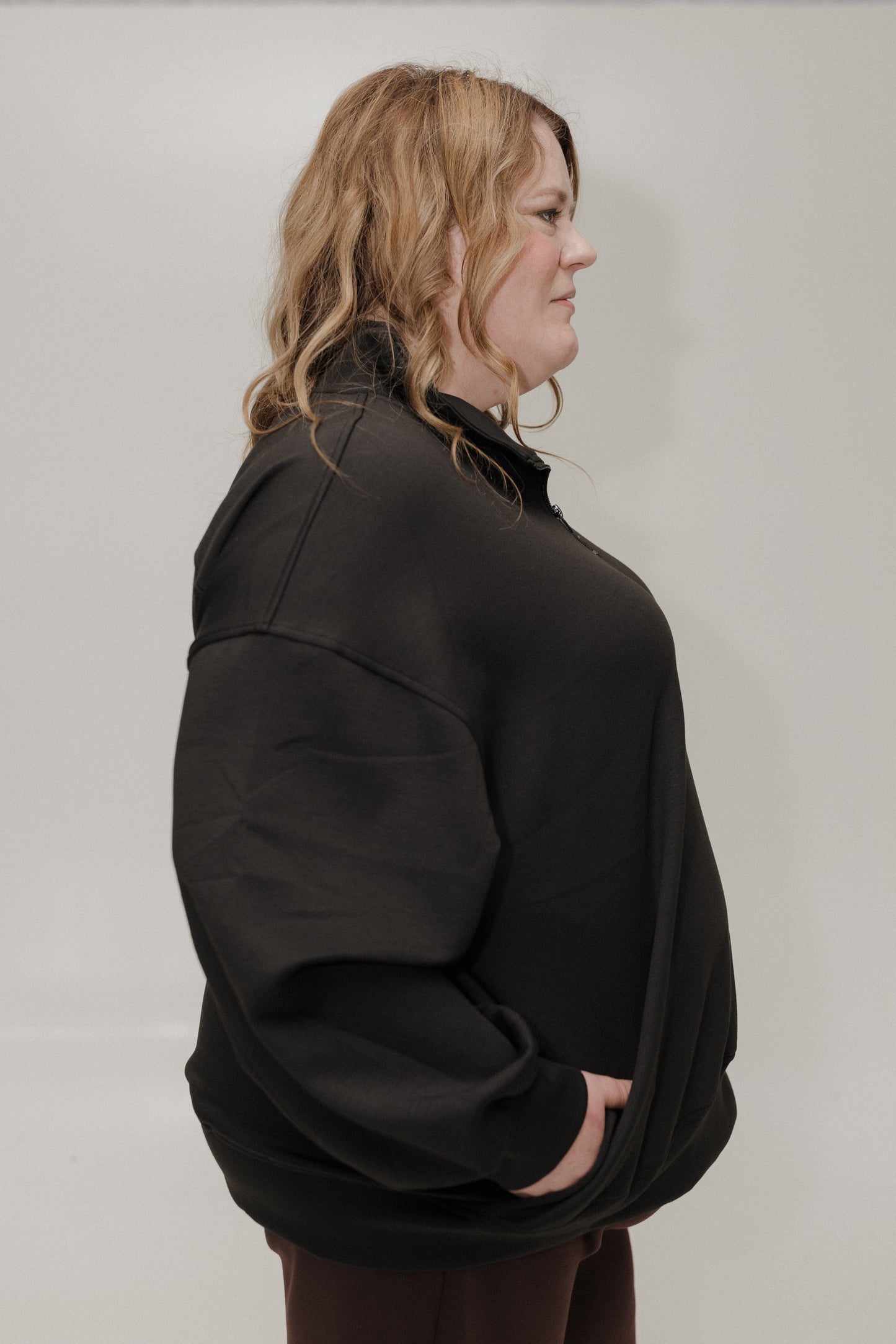 Person wearing a black jacket against a plain background