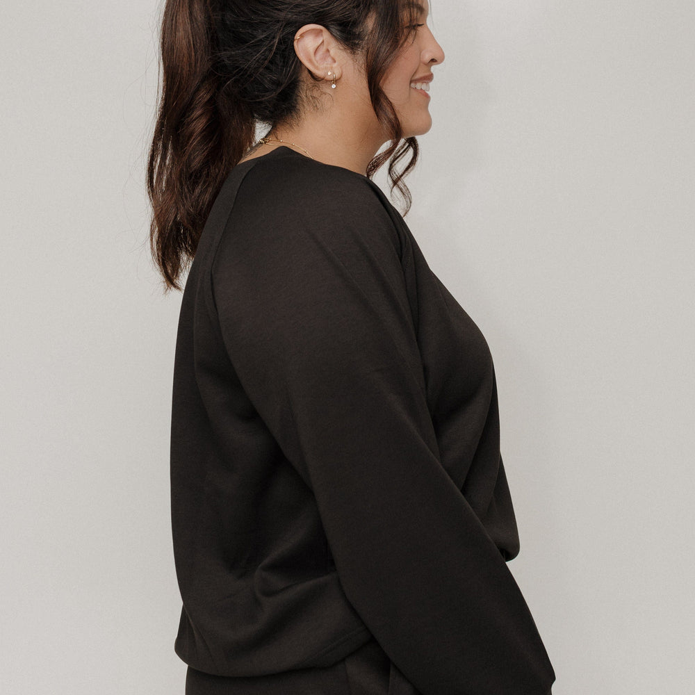 Woman wearing a black outfit against a plain background