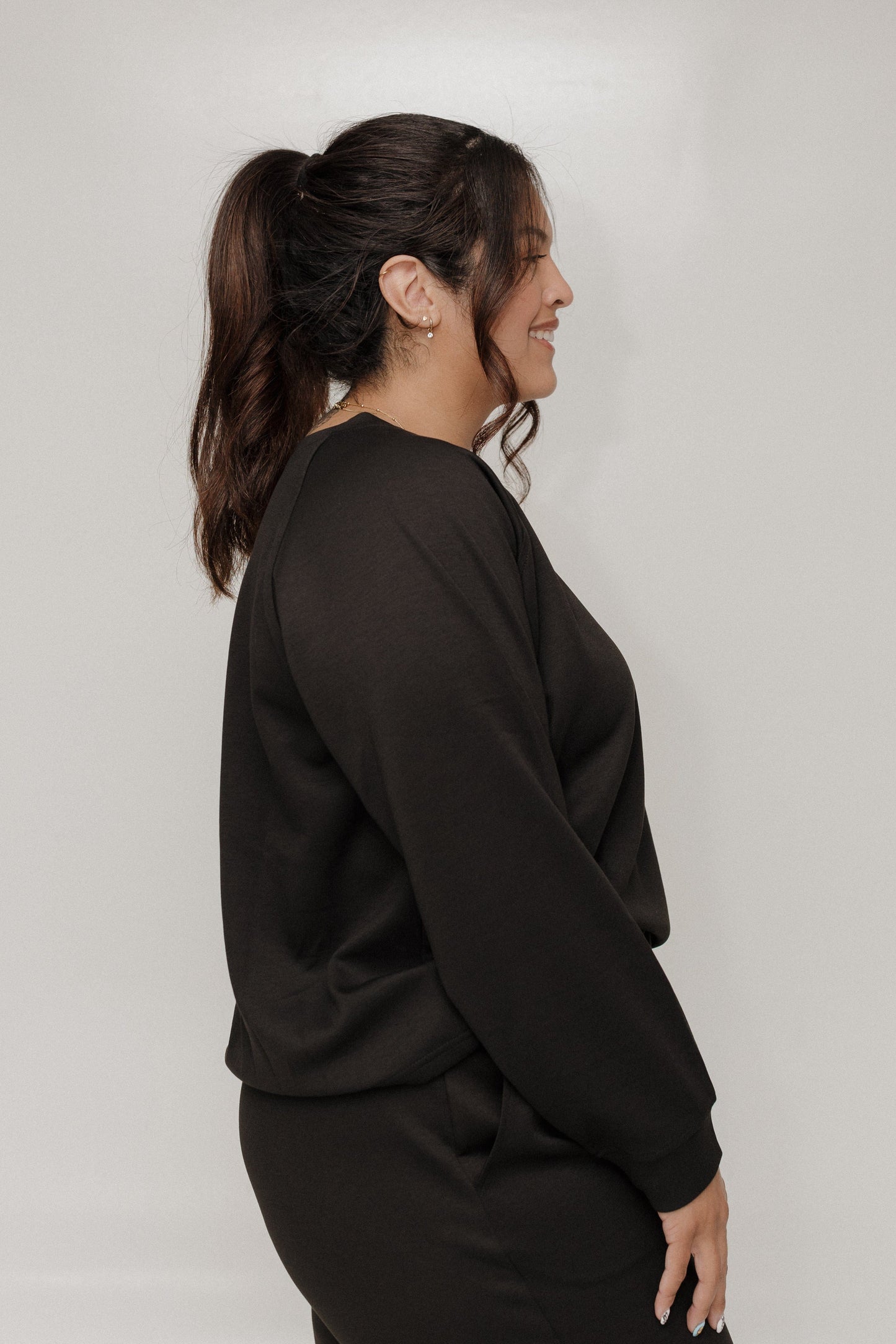 Woman wearing a black outfit against a plain background