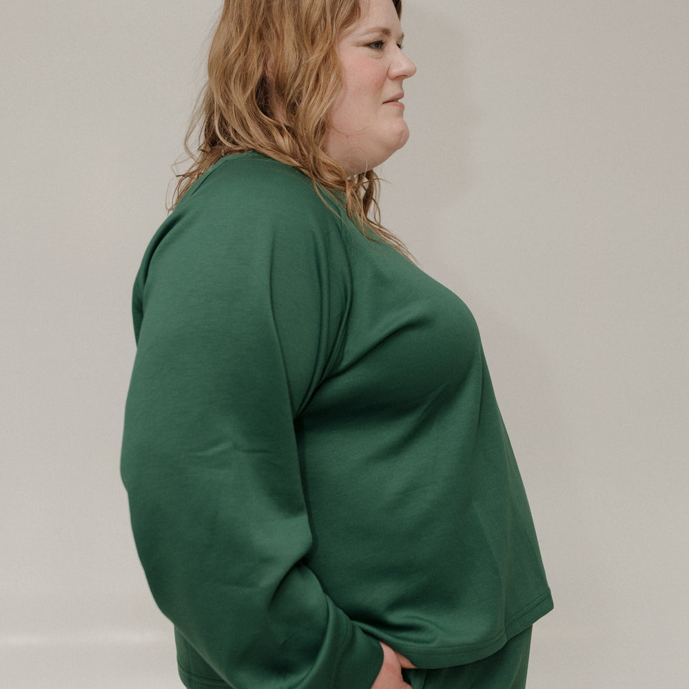 Person wearing a green outfit against a plain background