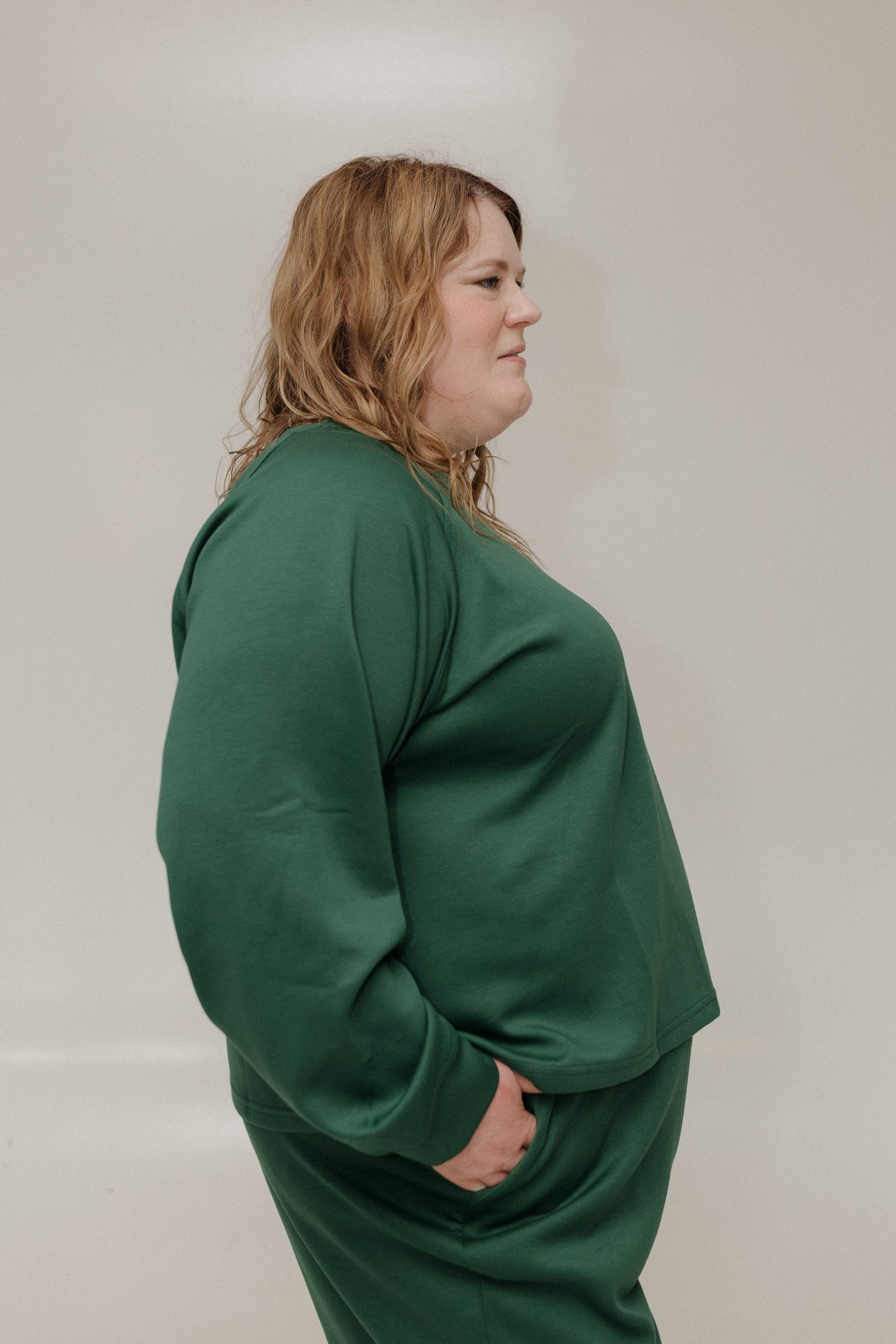 Person wearing a green outfit against a plain background