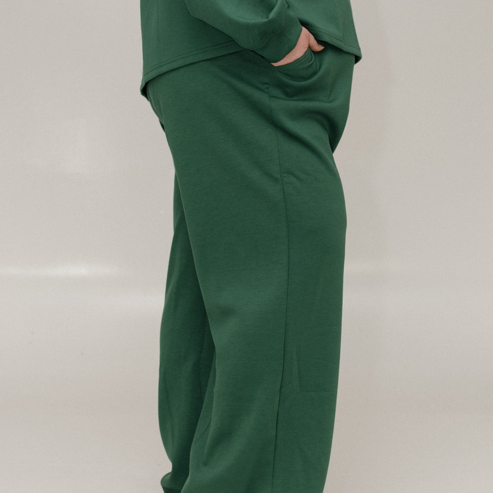 Green outfit with a top and pants on a plain background