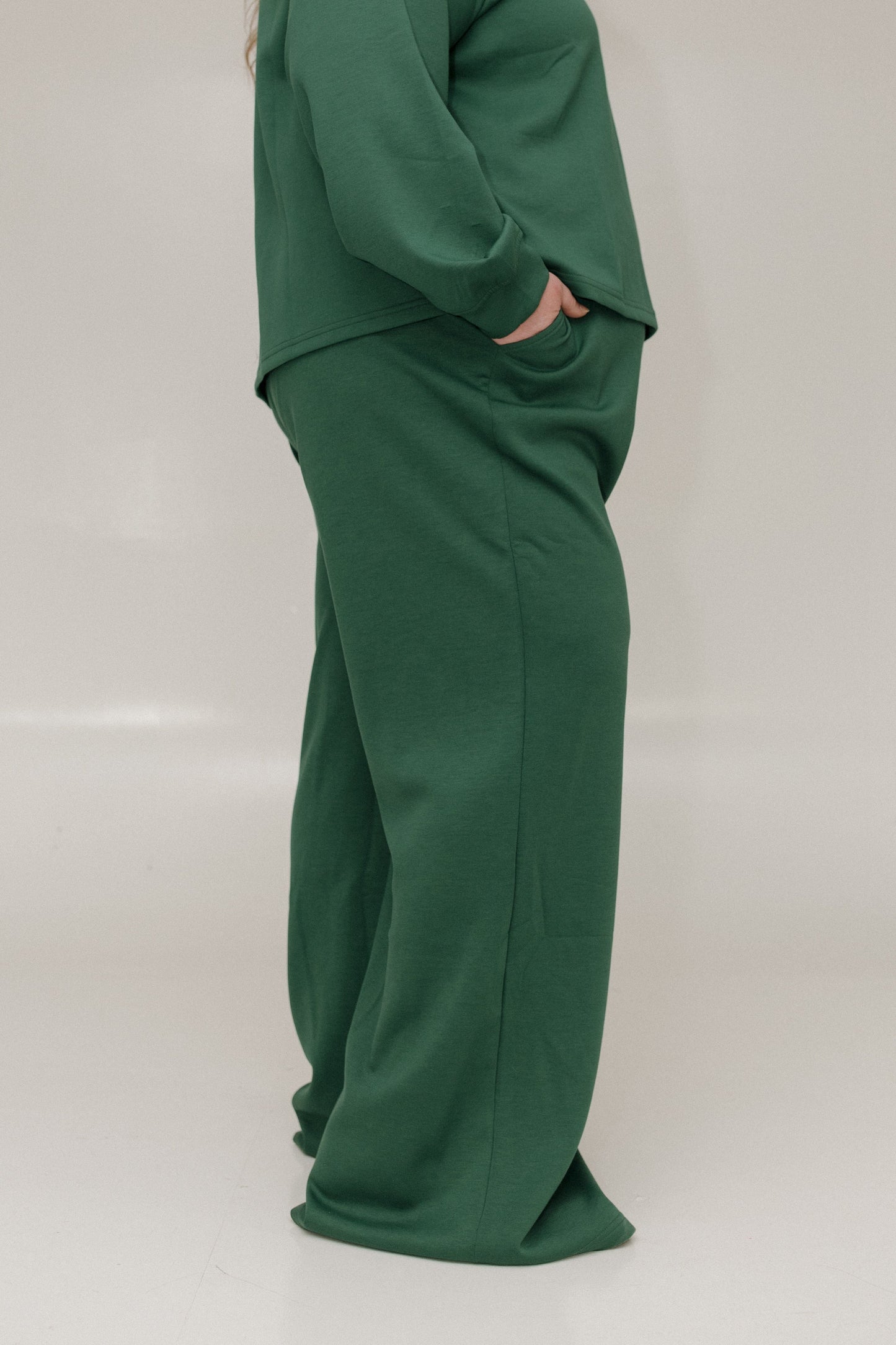 Green outfit with a top and pants on a plain background