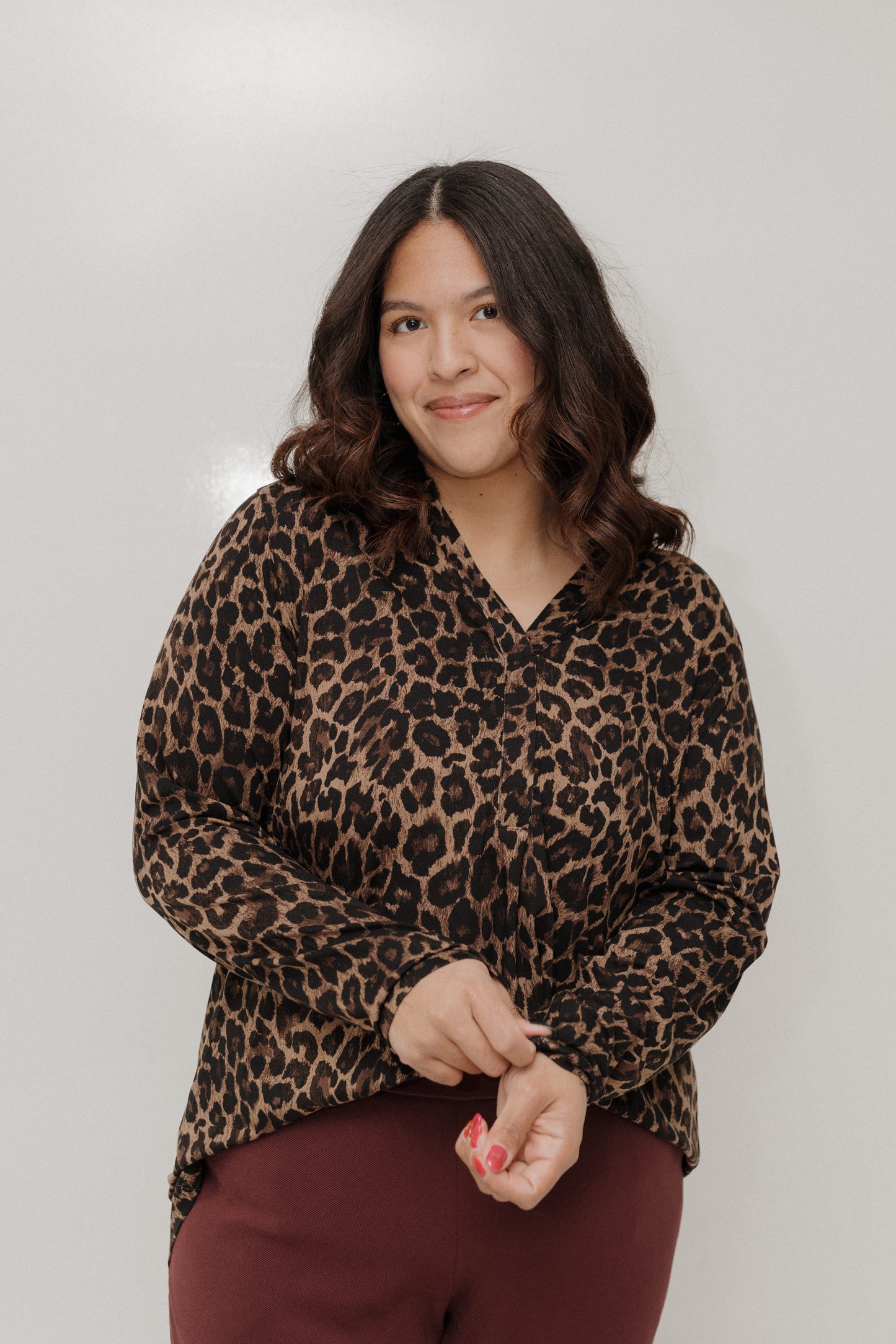 Woman wearing a leopard print shirt against a plain background