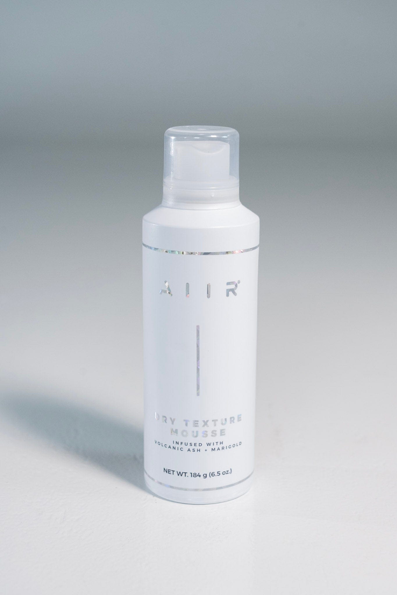 White bottle with 'AIR' branding on a gray background