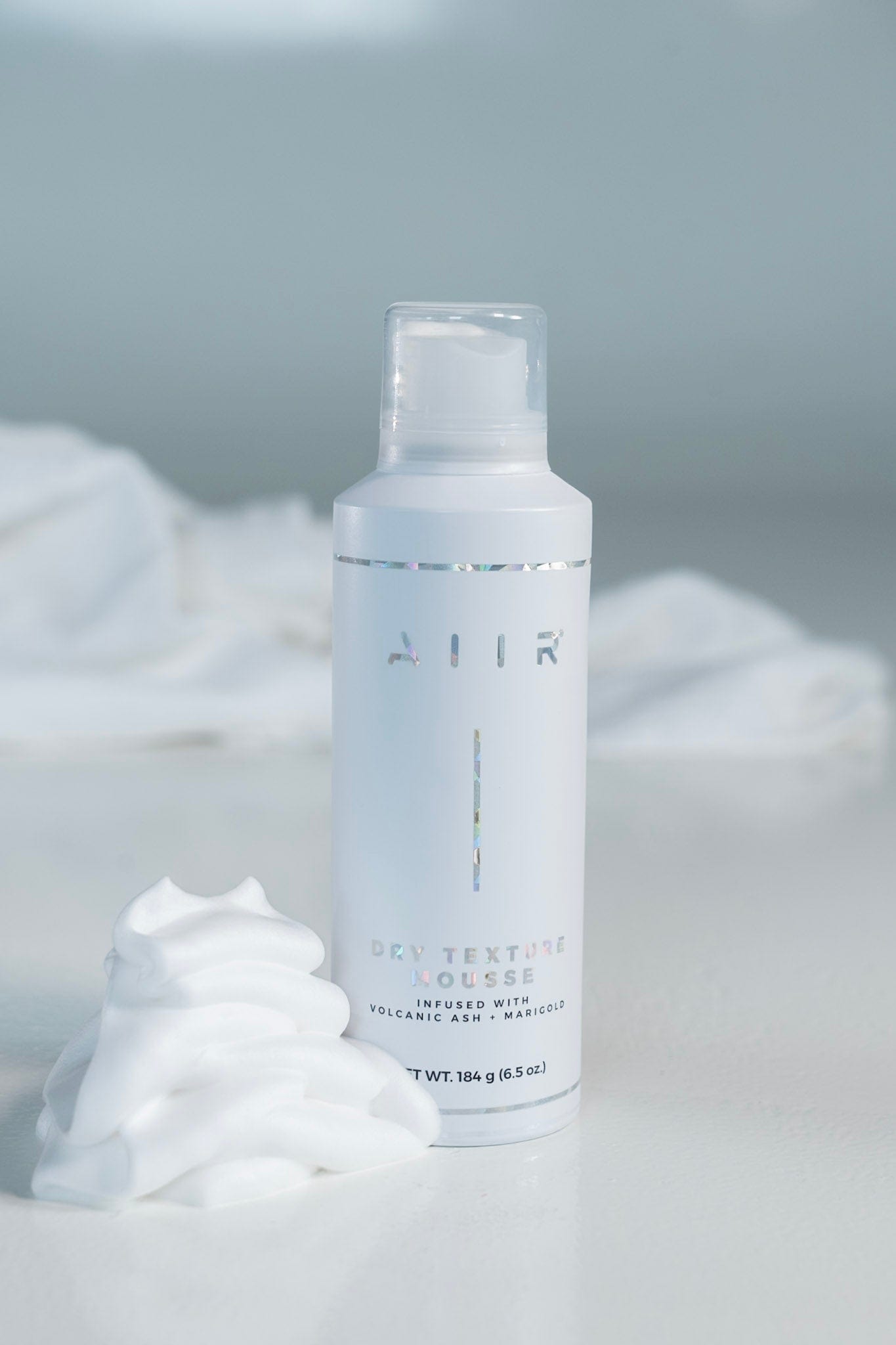 Skincare bottle labeled 'AIR' with white cream on a light gray background