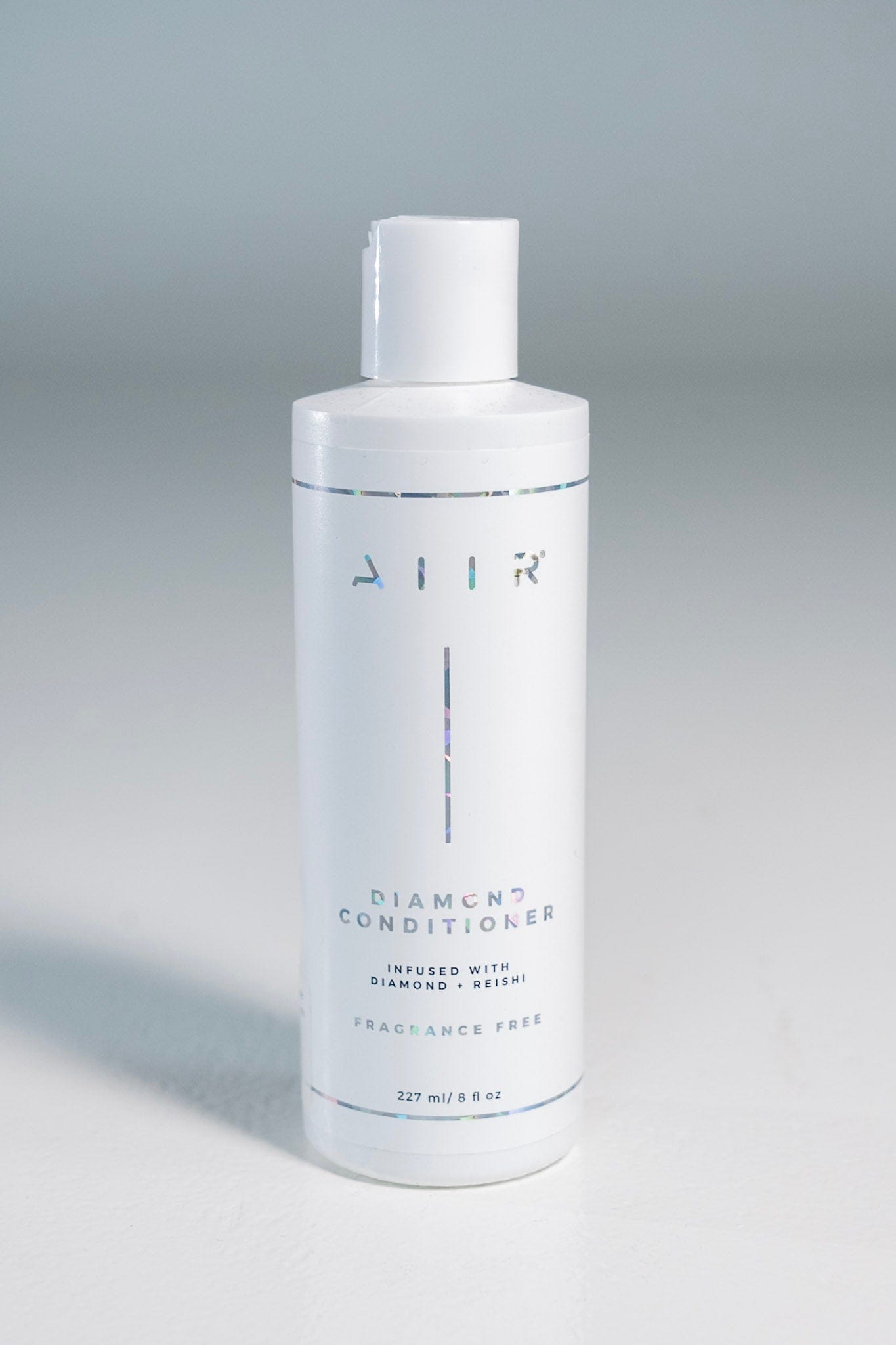 Bottle of 'AIIR' diamond conditioner on a gray background