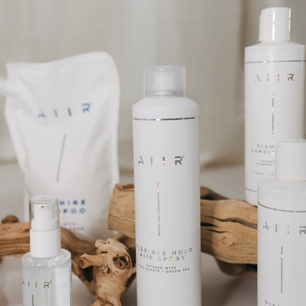 Set of AIIR hair care products including shampoo, conditioner, and other items on a neutral background.