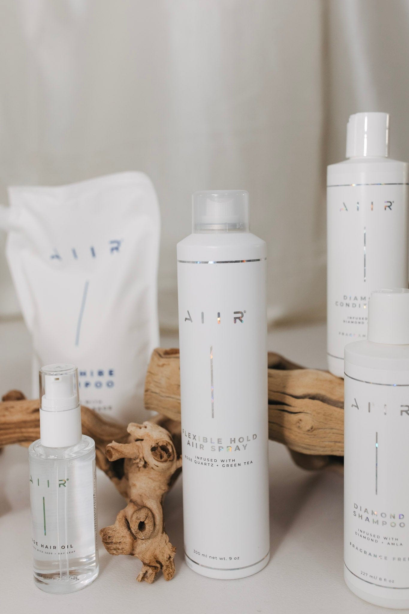 Set of AIIR hair care products including shampoo, conditioner, and other items on a neutral background.