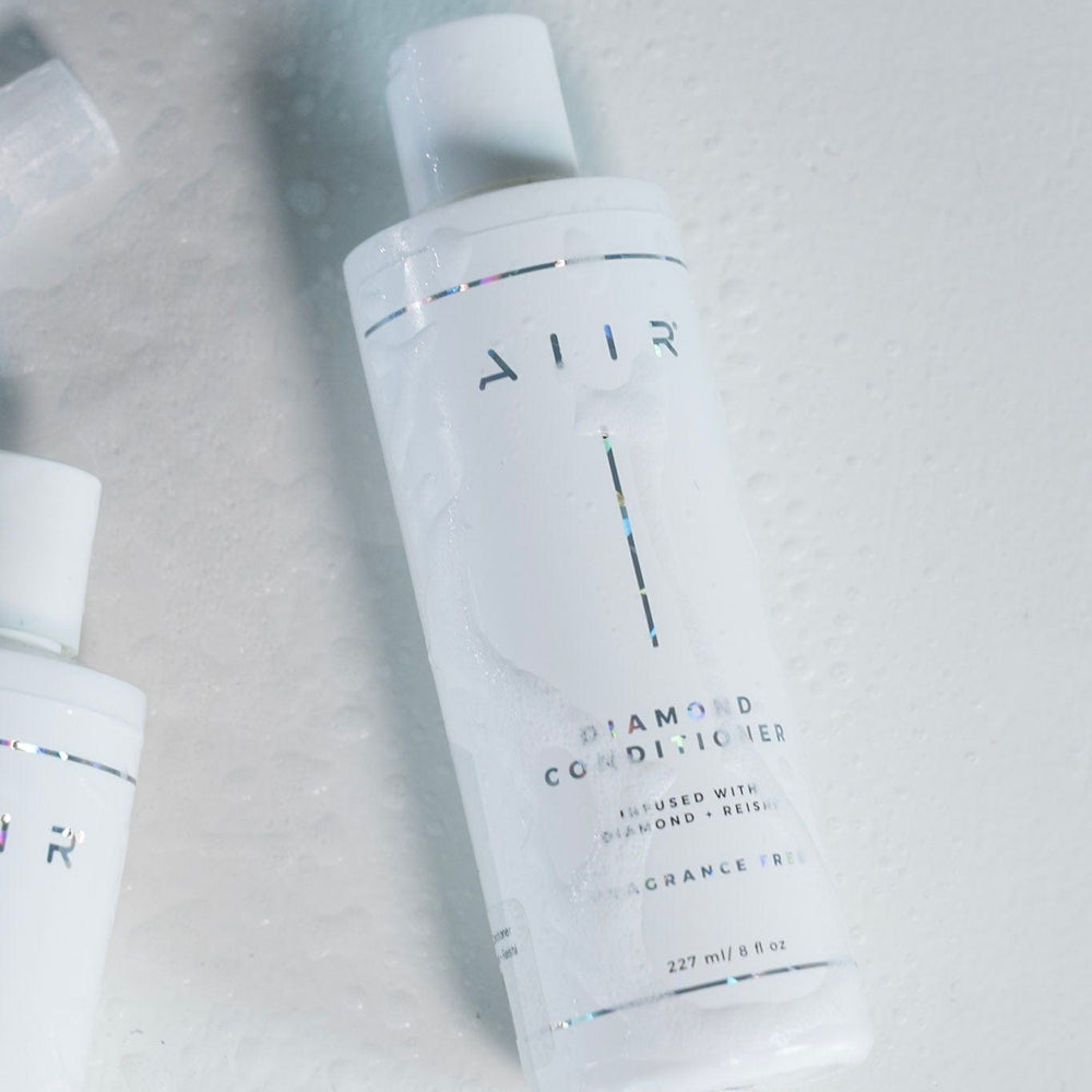 Two bottles of Allur diamond conditioner on a light gray background