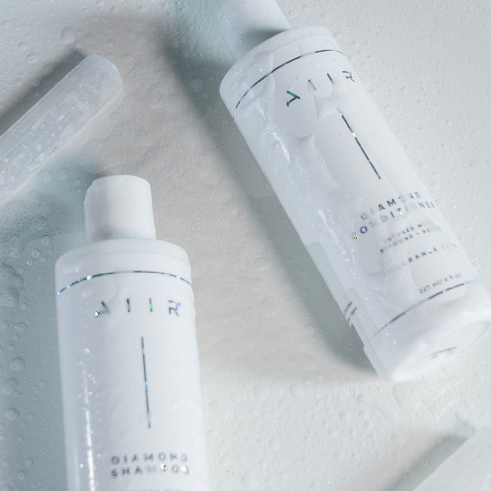 Two white shampoo bottles with 'AIR' branding on a light gray background
