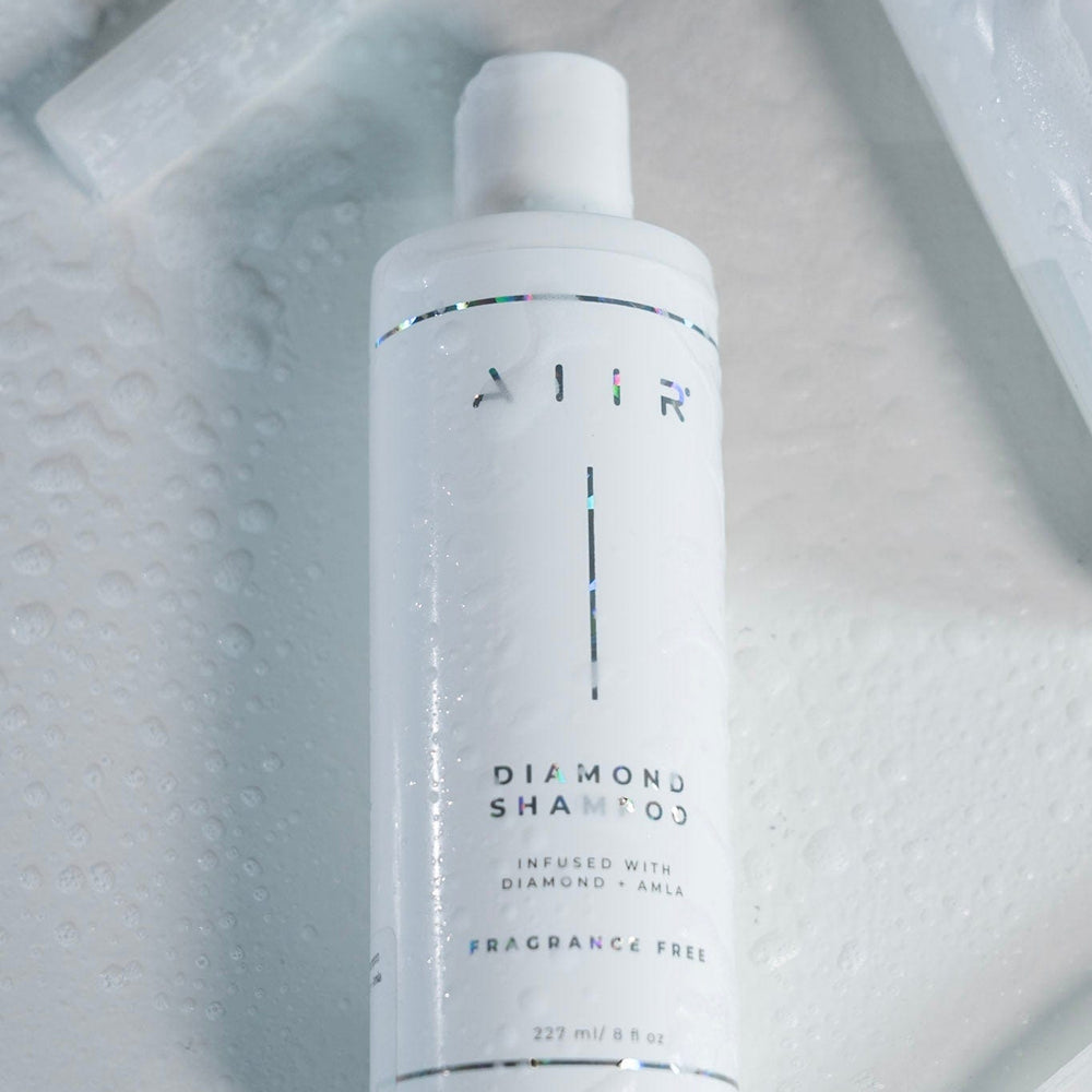 White shampoo bottle with 'AIR' branding on a marble surface