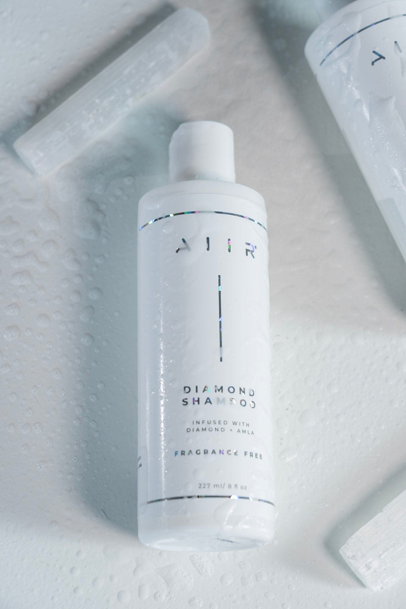 White shampoo bottle with 'AIR' branding on a marble surface