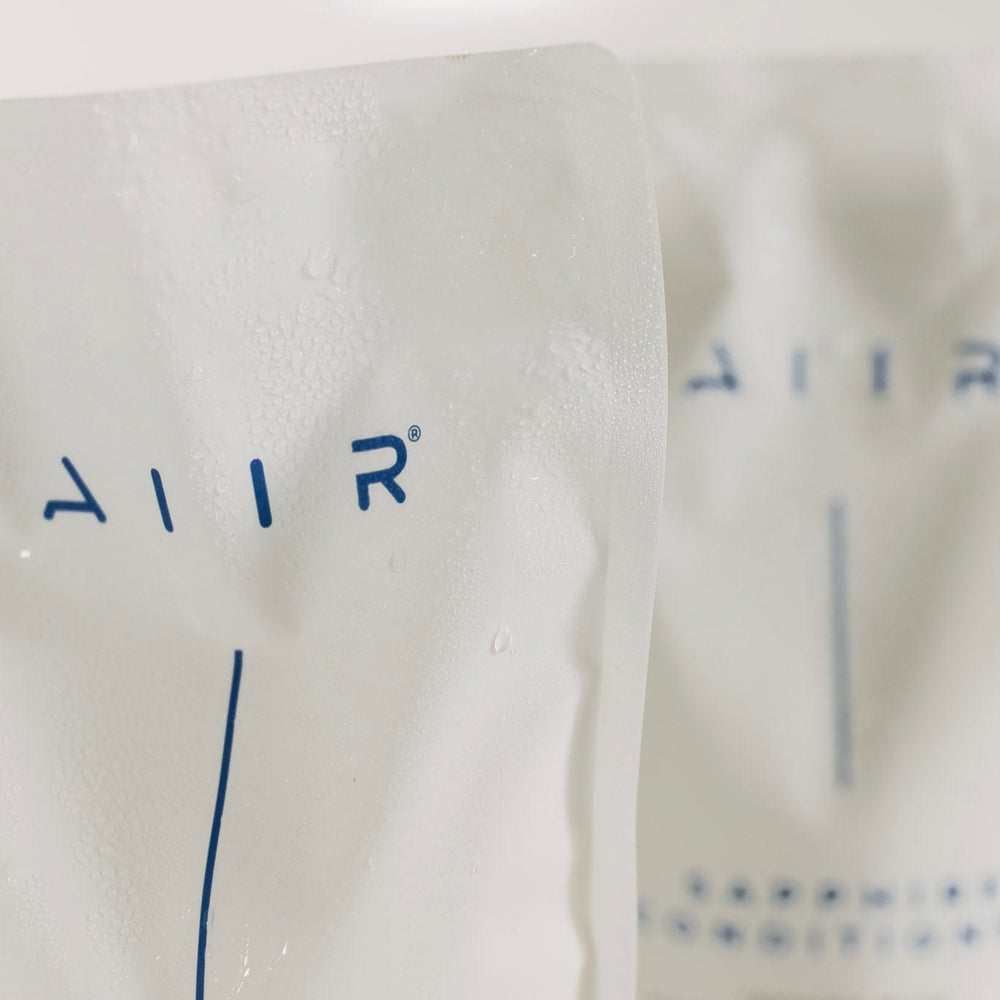 Close-up of a bottle labeled 'AIIR' with 'Sapphire Shampoo' text on a white background.