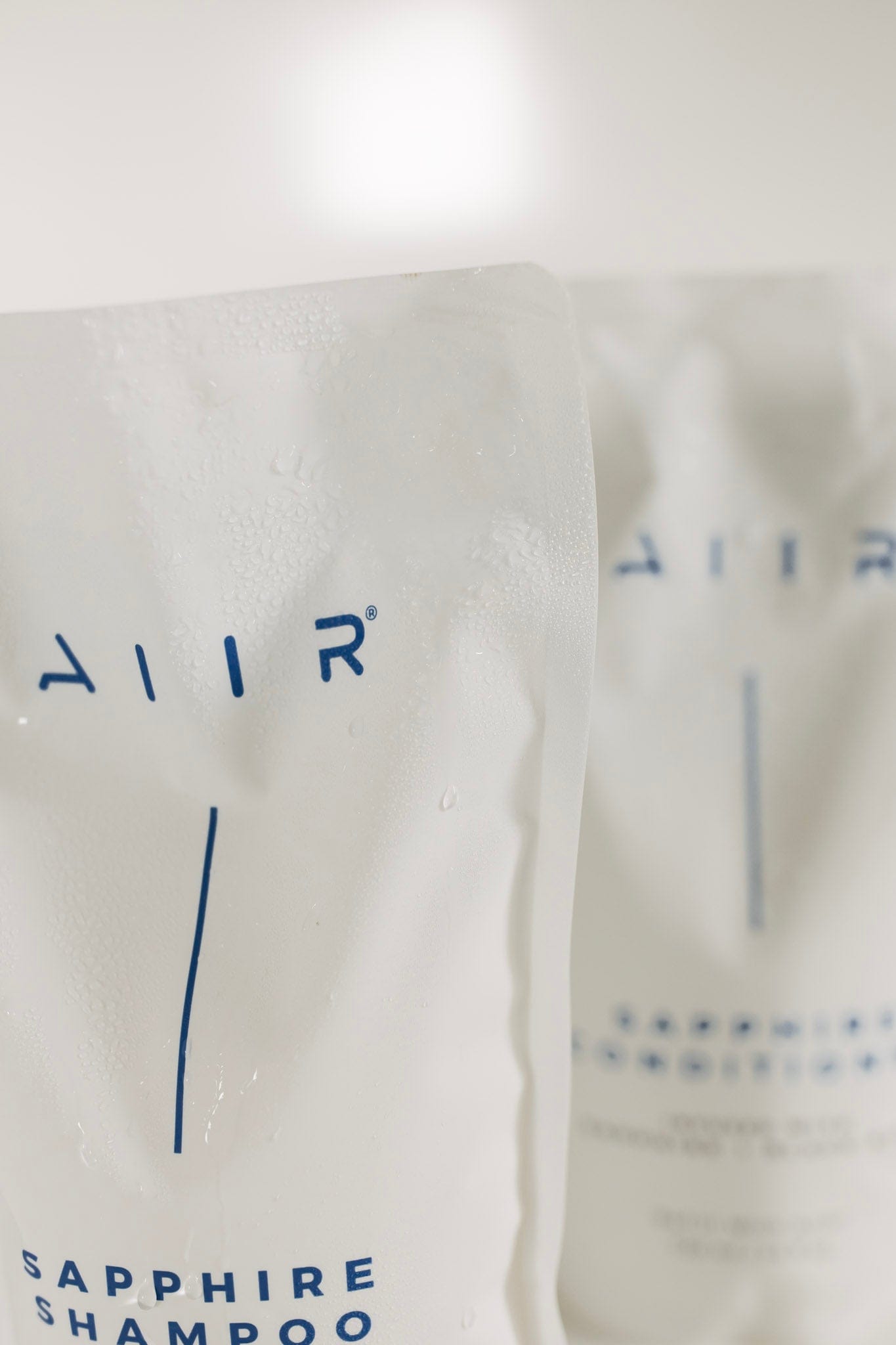 Close-up of a bottle labeled 'AIIR' with 'Sapphire Shampoo' text on a white background.