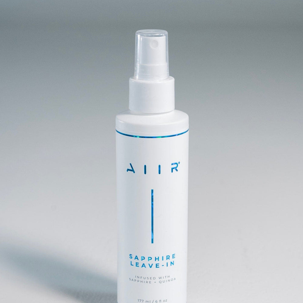 White spray bottle labeled 'AIR' on a gray background