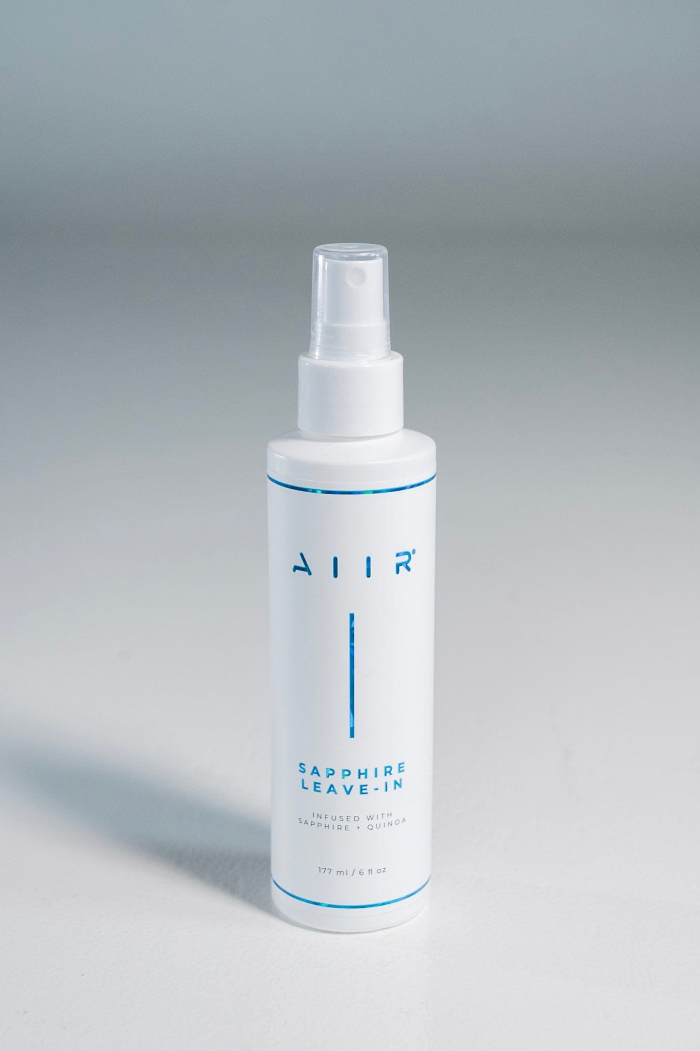 White spray bottle labeled 'AIR' on a gray background