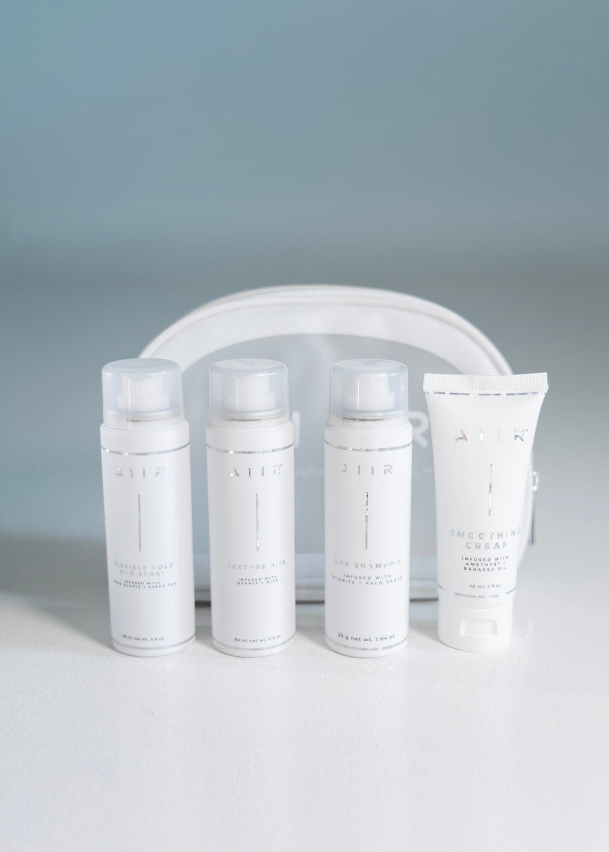 Set of skincare products with a clear pouch on a gray background