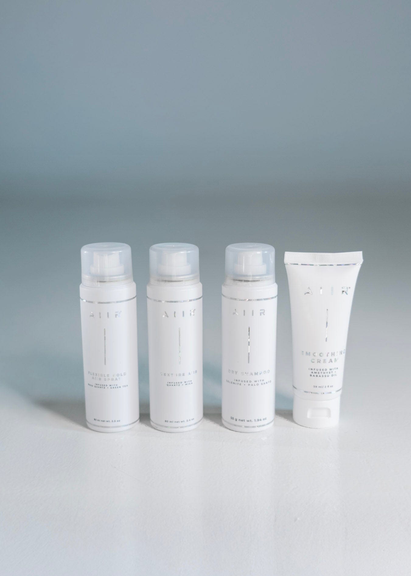 Four white skincare products on a gray background