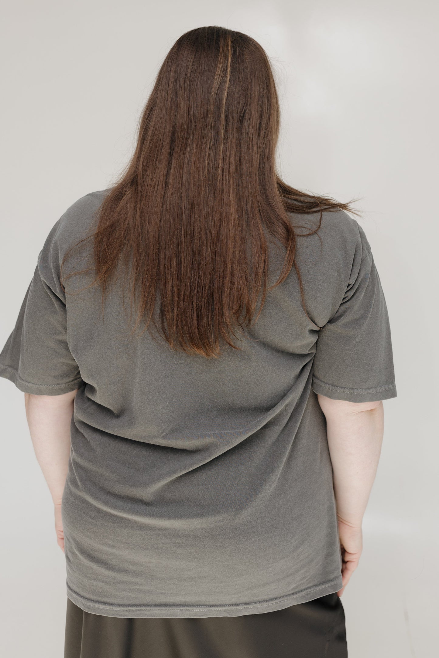 Person wearing a gray t-shirt against a plain background