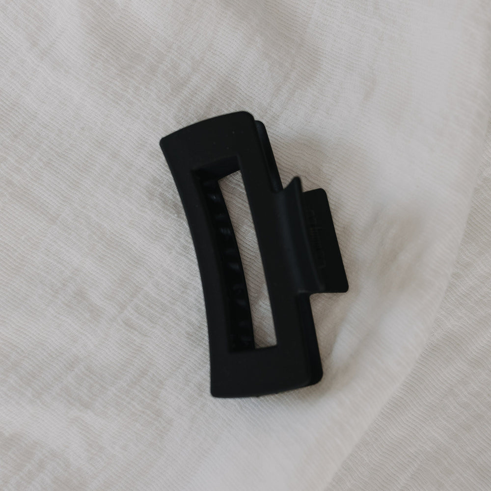 Black hair claw on a white fabric background