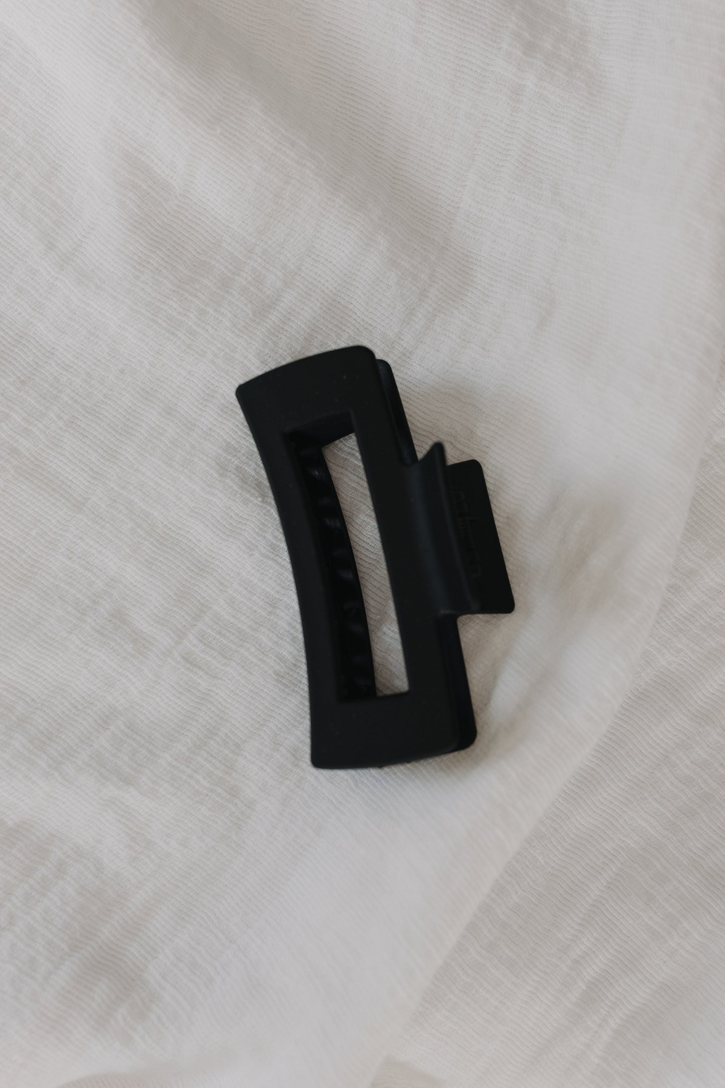Black hair claw on a white fabric background