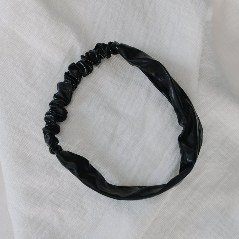 Black hairband on a white textured fabric background