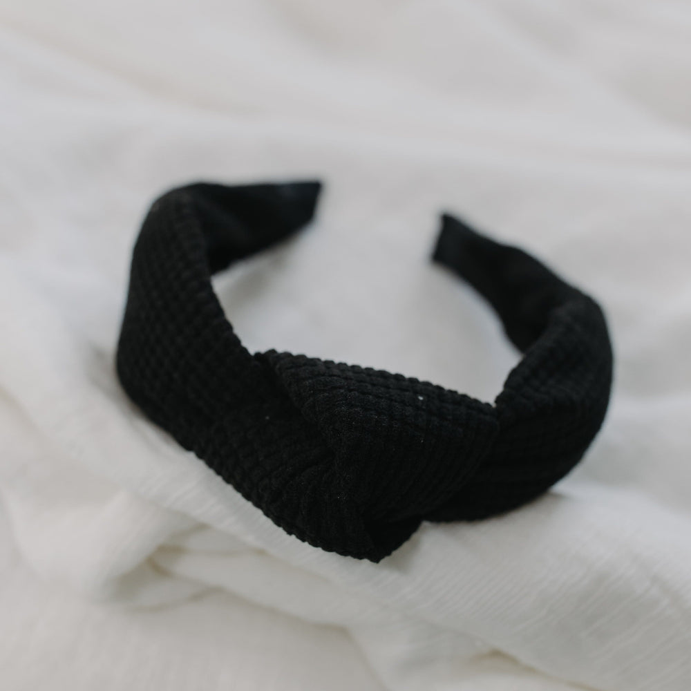 Black waffle texture headband against a white background