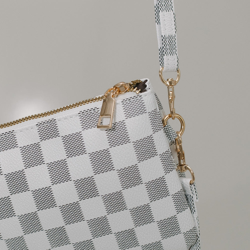 Checkered handbag with a strap on a neutral background