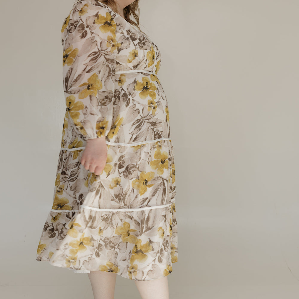 Woman wearing a floral dress against a plain background