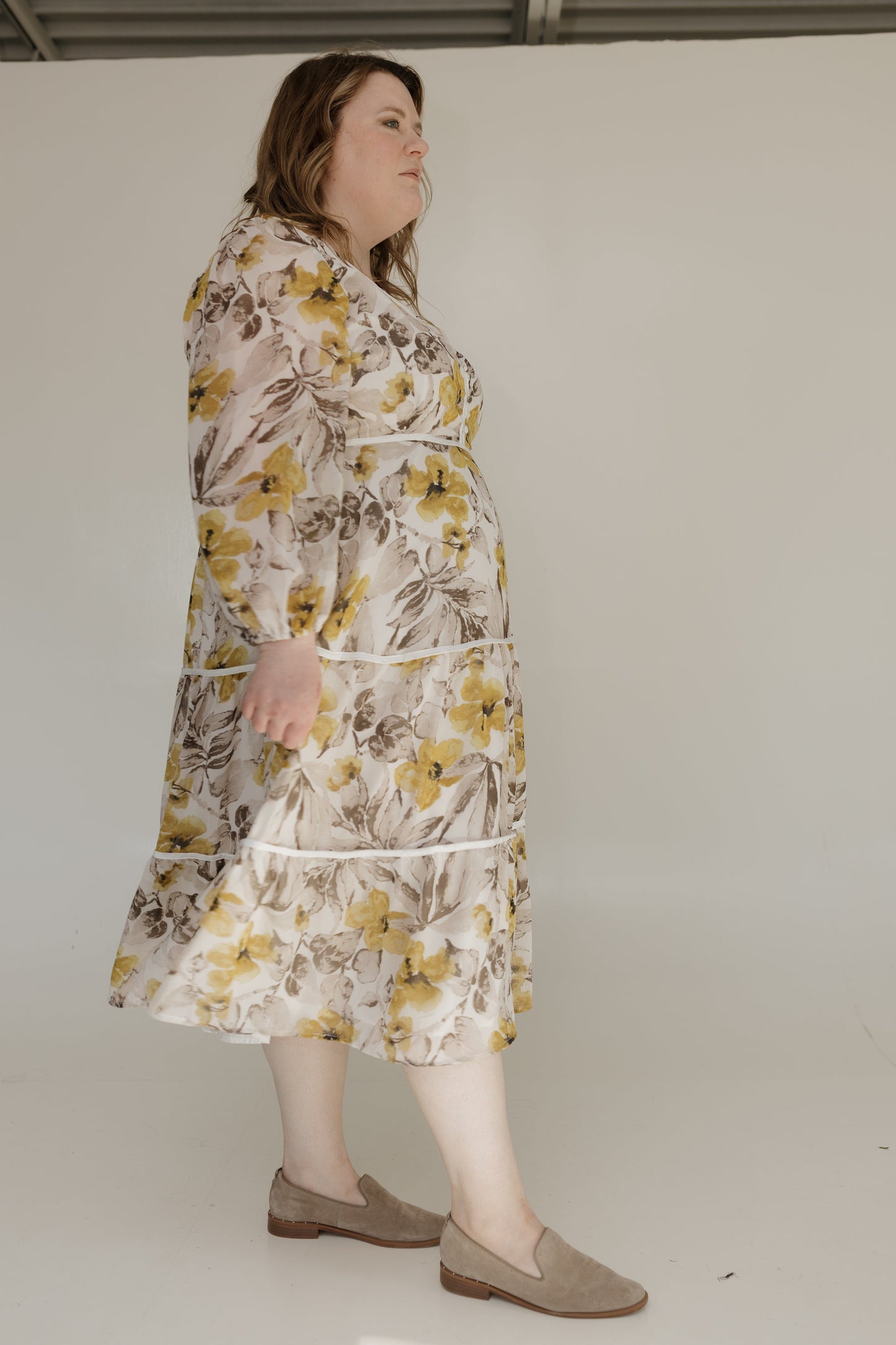 Woman wearing a floral dress against a plain background