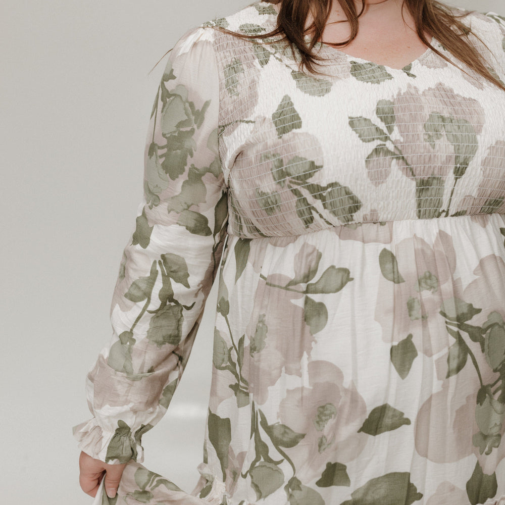 Woman wearing a floral dress against a plain background