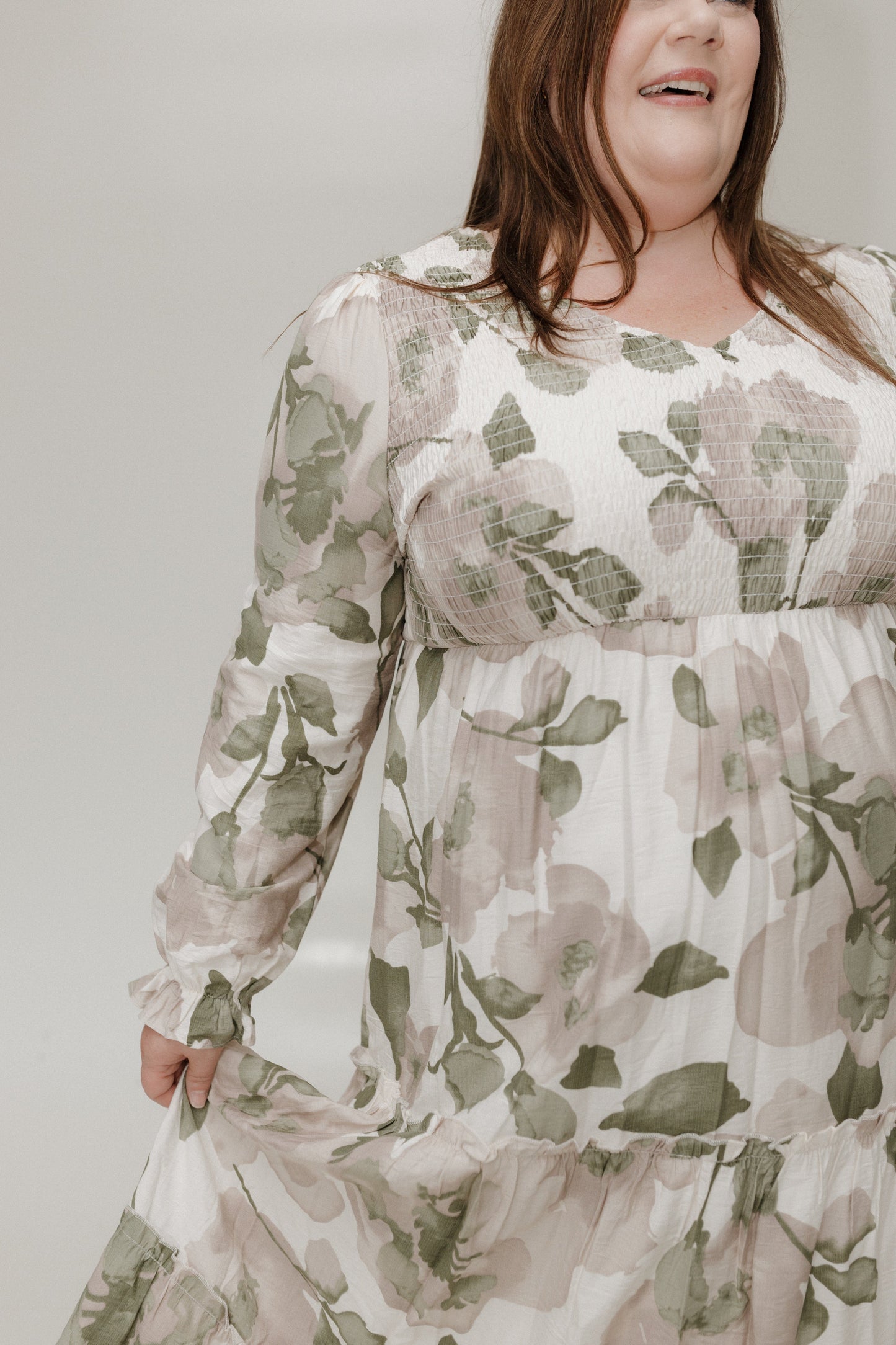 Woman wearing a floral dress against a plain background