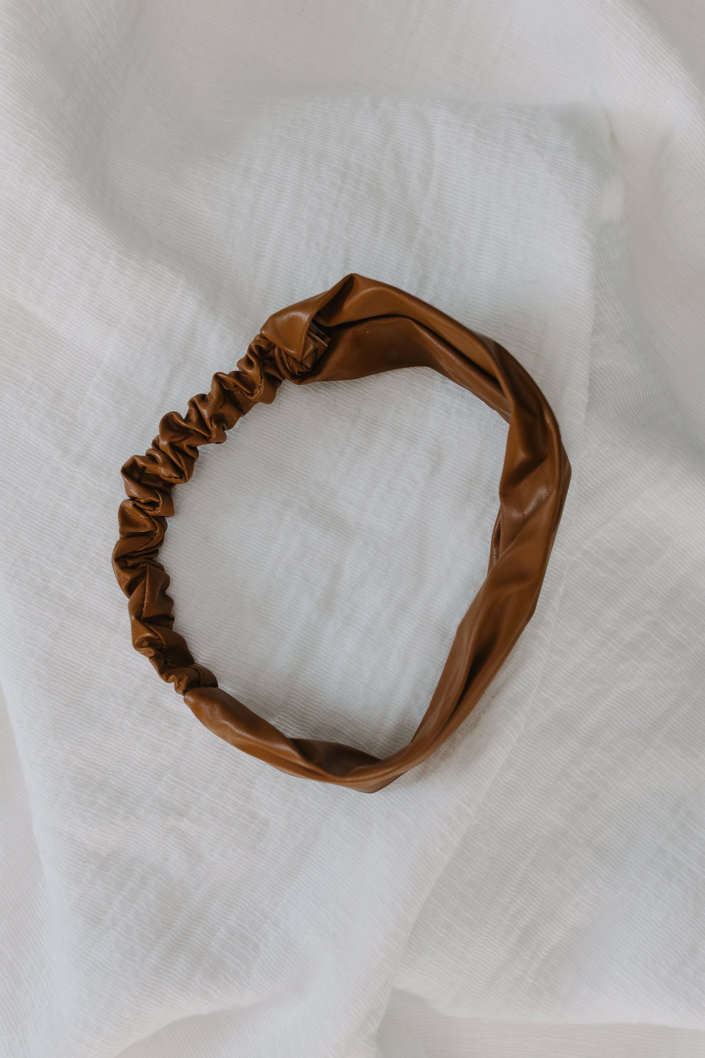 Brown headband on a white fabric background